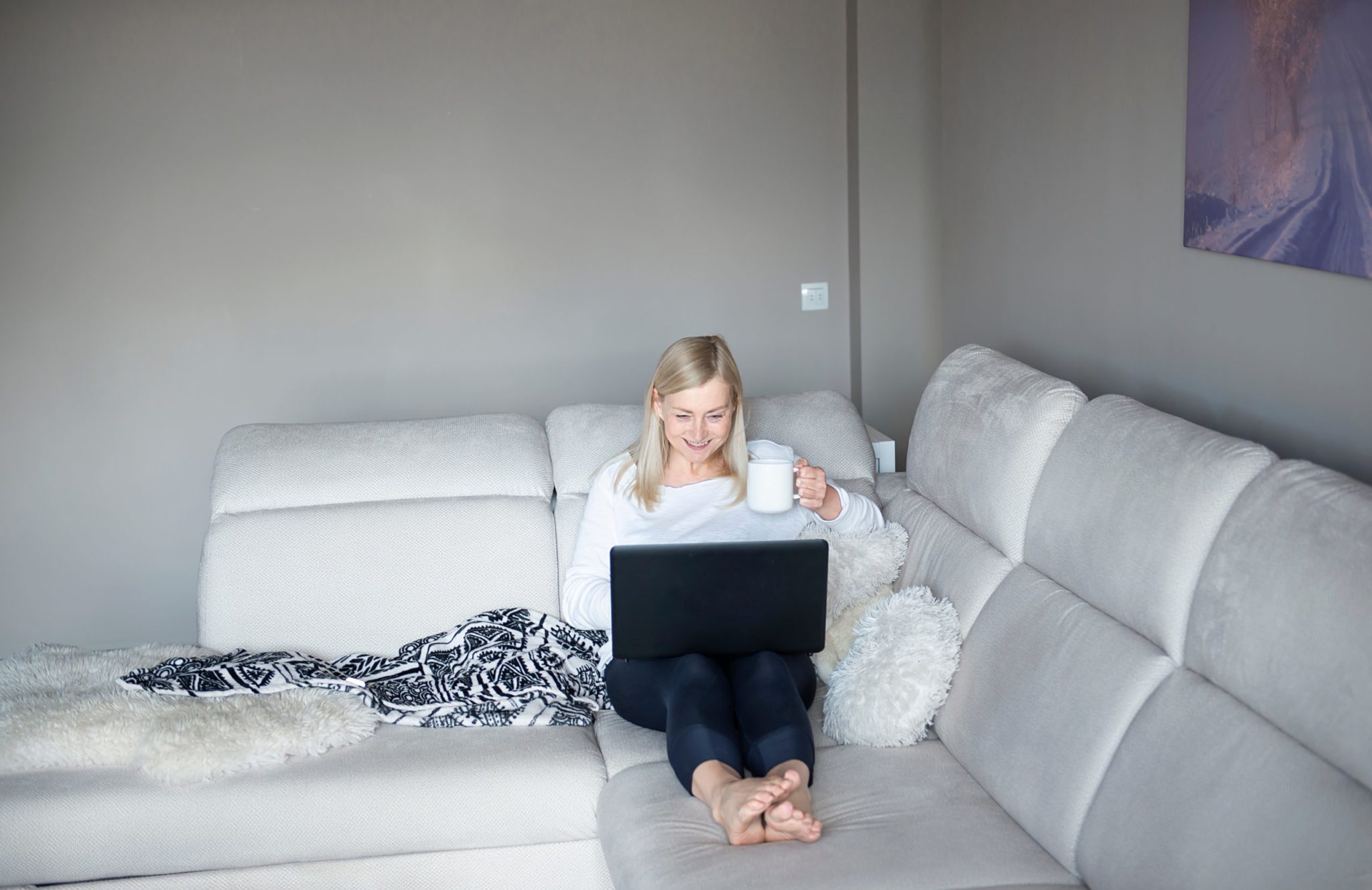 a person sitting on a couch with a laptop