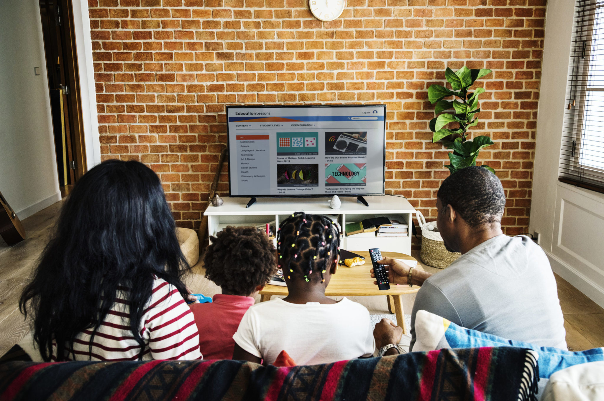 a group of people sitting around a table looking at a computer screen