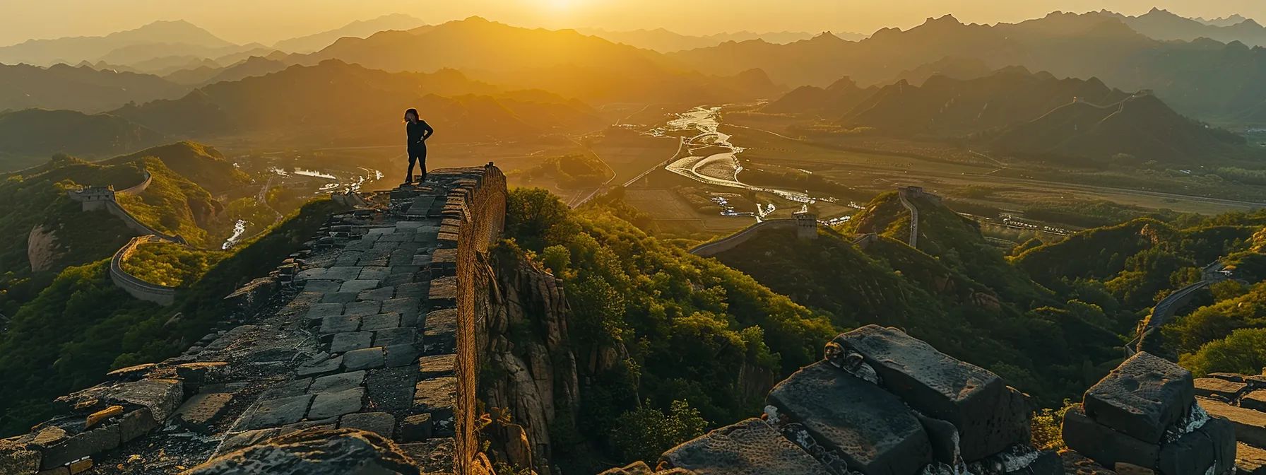 在夕阳余晖下,探险导游站在长城雄伟壮丽的顶端,俯瞰着层层叠叠的石墙和远处金色的山川。