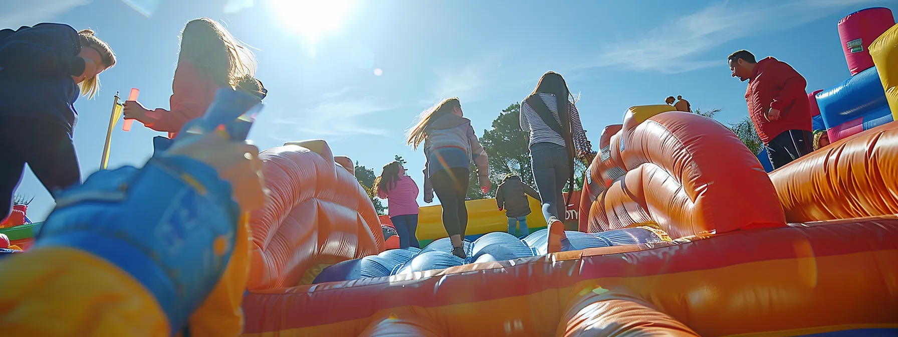a group of people inspecting and tightening anchors on a bounce house.