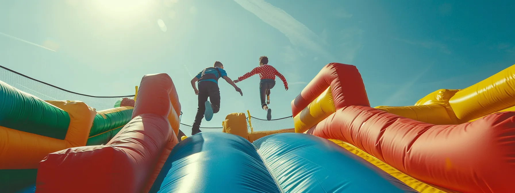 two individuals securing anchors on a bouncy castle in the windy conditions.